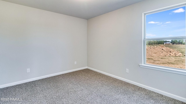 spare room with baseboards and carpet