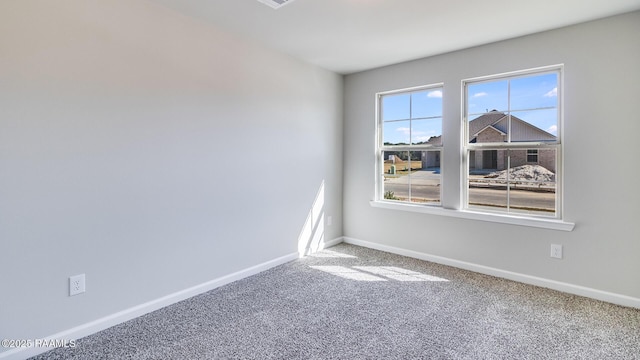 spare room featuring carpet flooring and baseboards