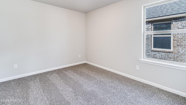 unfurnished room with baseboards and carpet