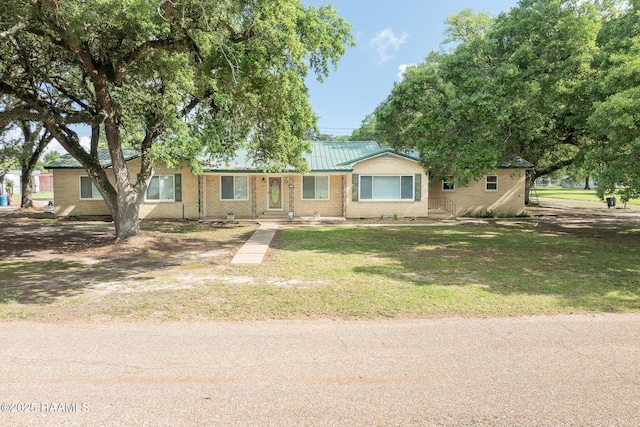 view of front facade featuring brick siding and a front yard