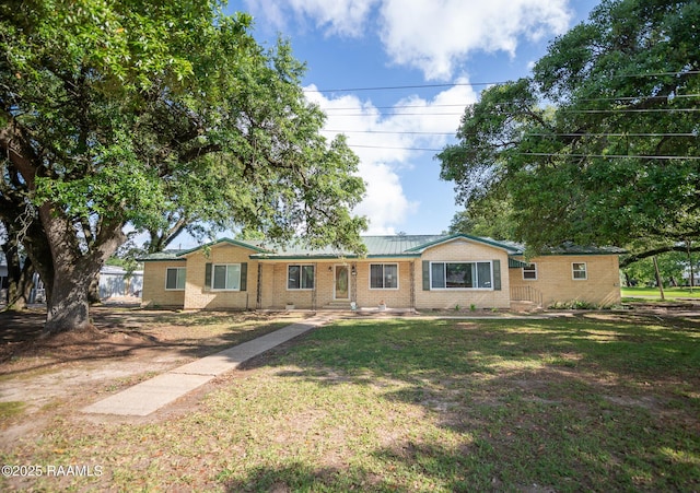 single story home with brick siding and a front yard