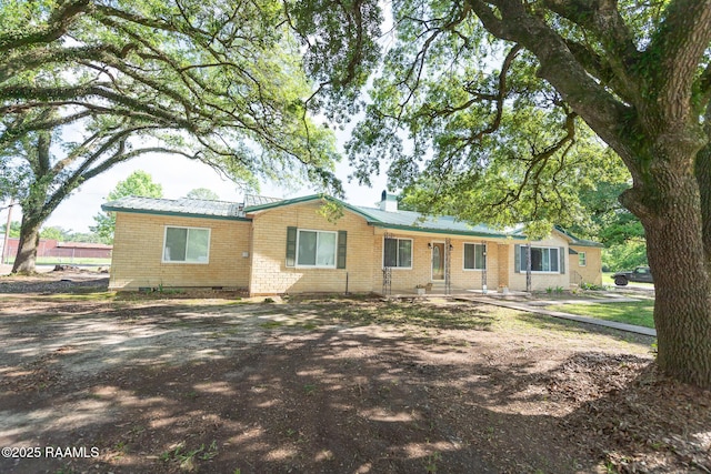 ranch-style home with brick siding and metal roof
