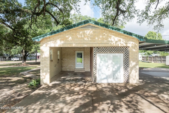 garage with fence and an attached carport