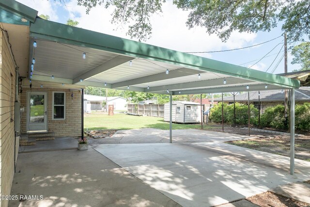 view of parking with entry steps, a shed, and fence