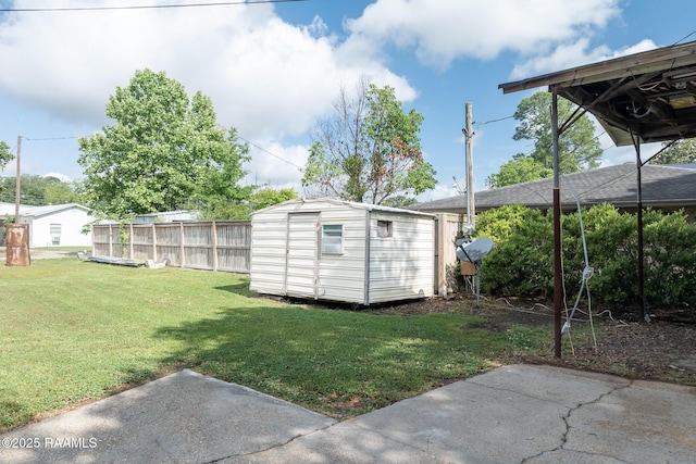 view of yard with a storage shed, fence, and an outbuilding