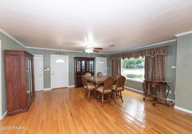 dining area with crown molding, a ceiling fan, baseboards, and light wood-style floors