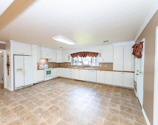 kitchen with visible vents, white appliances, white cabinetry, a sink, and backsplash
