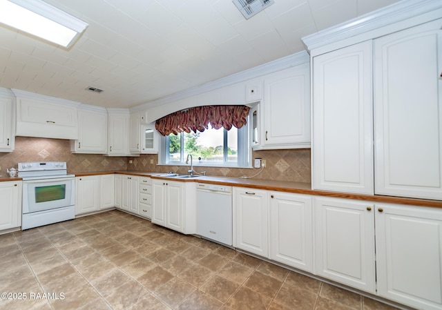 kitchen with visible vents, a sink, white appliances, and tasteful backsplash