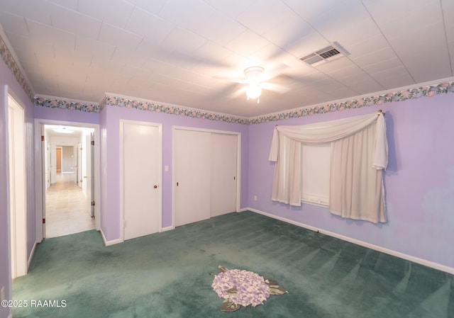 unfurnished bedroom featuring visible vents, carpet flooring, baseboards, and two closets