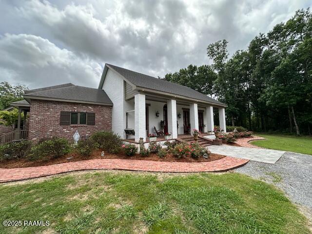 10427 U S Highway 167, Abbeville, LA 70510 - view of front of house with a porch, brick siding, and a front yard