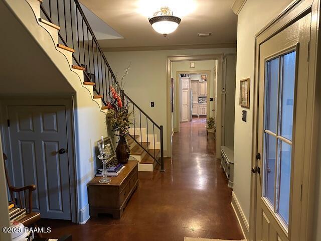 10427 U S Highway 167, Abbeville, LA 70510 - entryway featuring crown molding, baseboards, concrete flooring, and stairs