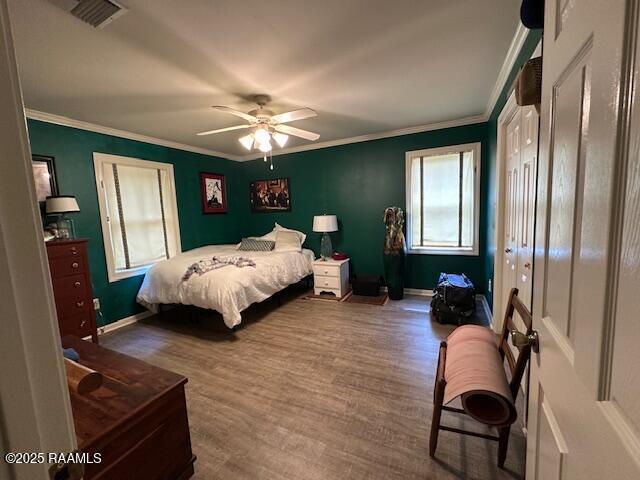 10427 U S Highway 167, Abbeville, LA 70510 - bedroom with a ceiling fan, visible vents, wood finished floors, baseboards, and ornamental molding
