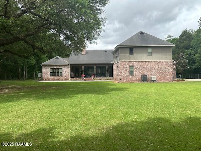 10427 U S Highway 167, Abbeville, LA 70510 - rear view of property with cooling unit, a yard, and brick siding
