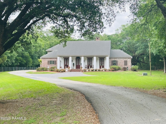 10427 U S Highway 167, Abbeville, LA 70510 - view of front of house with a porch, driveway, a chimney, fence, and a front lawn