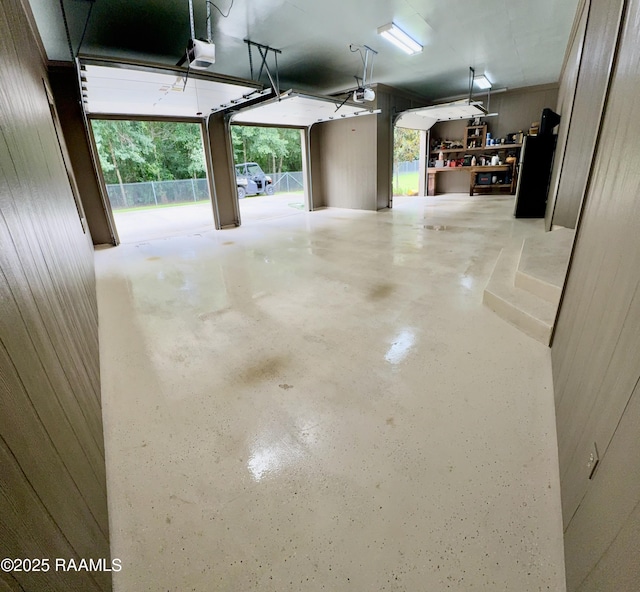 10427 U S Highway 167, Abbeville, LA 70510 - garage with wood walls, a garage door opener, and freestanding refrigerator