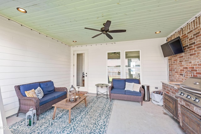 view of patio / terrace with exterior kitchen, an outdoor living space, and a ceiling fan