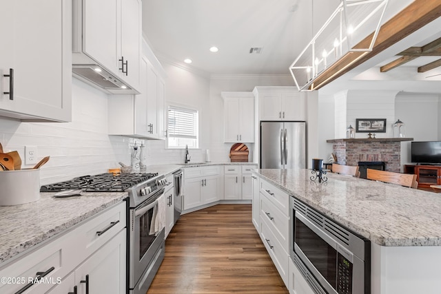 kitchen with a kitchen island, recessed lighting, under cabinet range hood, white cabinets, and stainless steel appliances