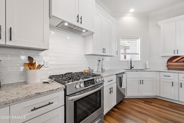 kitchen with backsplash, stainless steel appliances, white cabinetry, and a sink