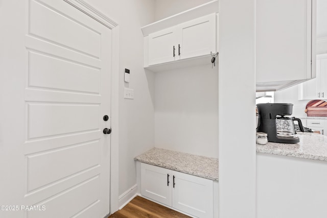 mudroom featuring dark wood-style flooring and baseboards