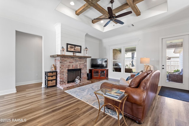 living area with ceiling fan, visible vents, a fireplace, wood finished floors, and coffered ceiling