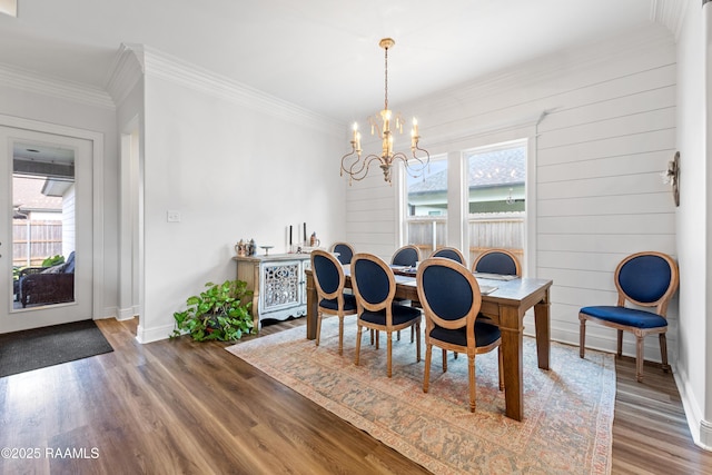 dining room with an inviting chandelier, baseboards, wood finished floors, and a healthy amount of sunlight