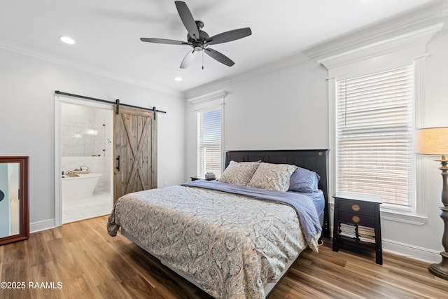 bedroom featuring multiple windows, a barn door, and wood finished floors