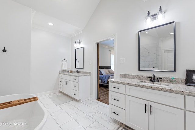 bathroom with crown molding, marble finish floor, a freestanding tub, recessed lighting, and a sink