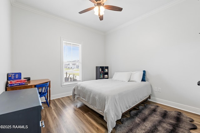 bedroom featuring crown molding, baseboards, and wood finished floors