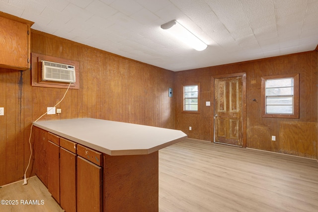 204 Tillou Andrus Dr, Opelousas, LA 70570 - kitchen with light wood-style floors, light countertops, brown cabinetry, a peninsula, and a wall mounted AC
