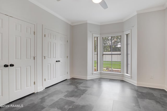 unfurnished bedroom with ornamental molding, two closets, ceiling fan, and baseboards