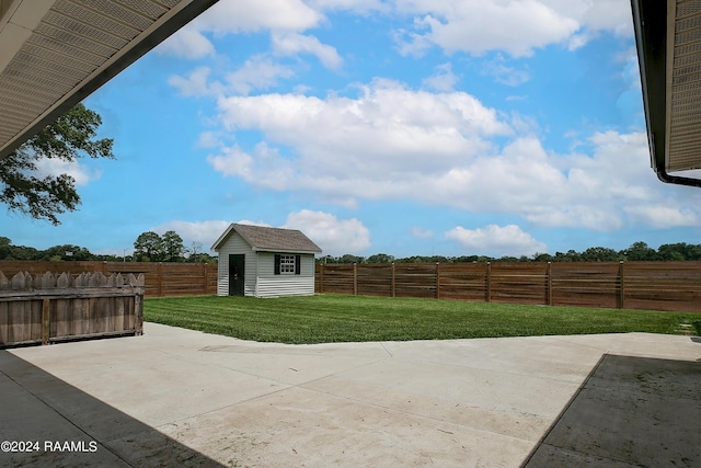 view of patio featuring an outdoor structure, a storage unit, and a fenced backyard