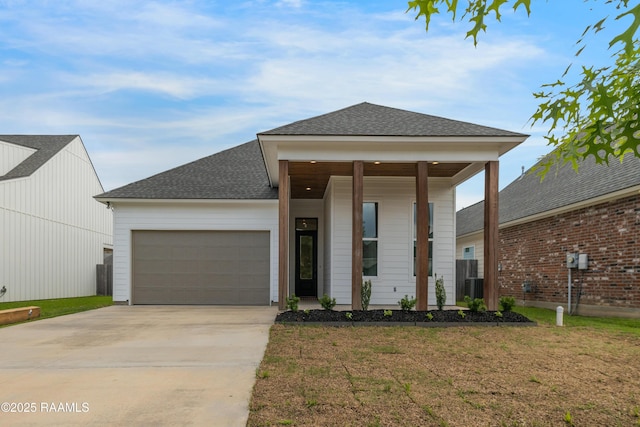 view of front facade featuring driveway, a shingled roof, covered porch, a front yard, and a garage