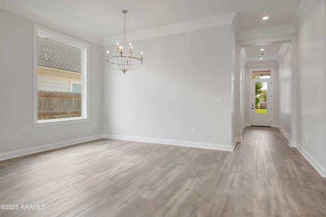 spare room featuring recessed lighting, wood finished floors, a chandelier, baseboards, and crown molding