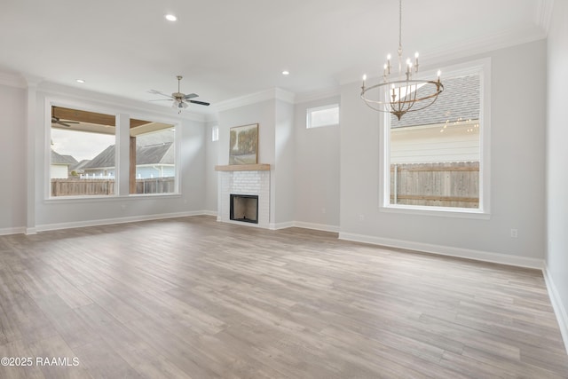 unfurnished living room featuring a fireplace, light wood finished floors, ornamental molding, and baseboards