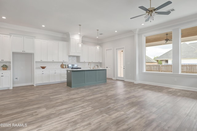 kitchen with light wood finished floors, a ceiling fan, white cabinetry, and open floor plan