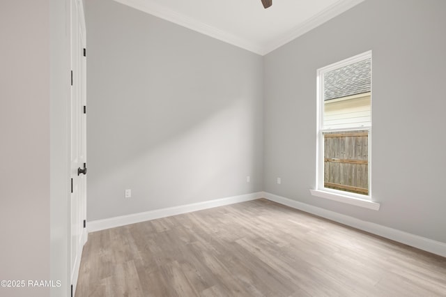 spare room with crown molding, ceiling fan, baseboards, and light wood-type flooring