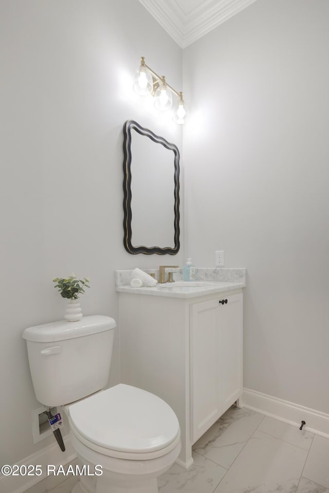 half bath with vanity, crown molding, toilet, marble finish floor, and baseboards