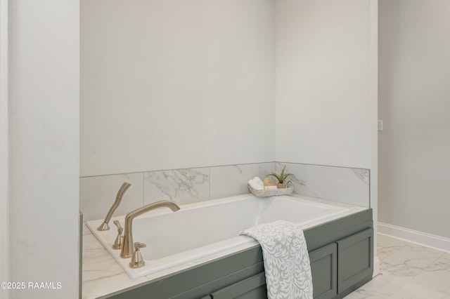 full bathroom featuring baseboards, a bath, and marble finish floor