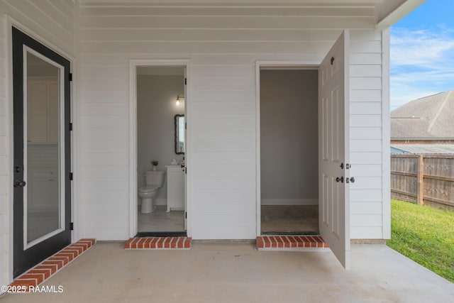 property entrance with fence and a patio area