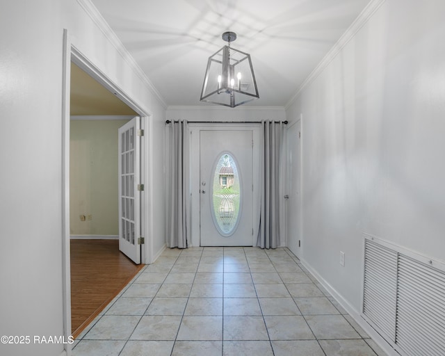 1621 Elm St, New Iberia, LA 70560 - foyer entrance with visible vents, baseboards, crown molding, and a notable chandelier