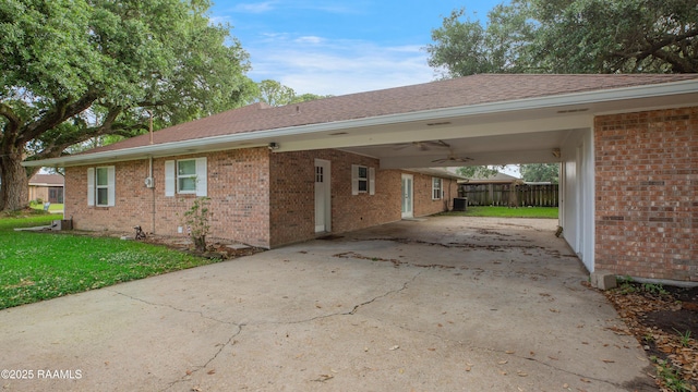 1621 Elm St, New Iberia, LA 70560 - view of property exterior featuring driveway, a lawn, a carport, brick siding, and fence