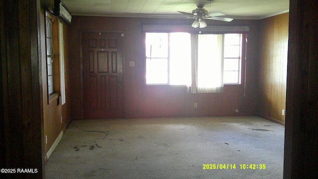 carpeted spare room with crown molding and ceiling fan