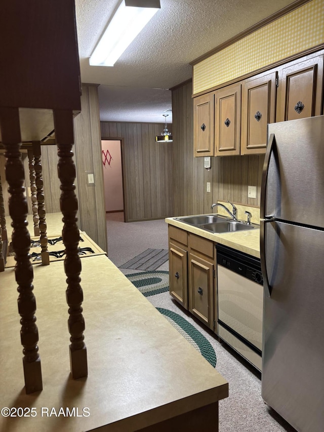 kitchen with freestanding refrigerator, a sink, carpet flooring, and white dishwasher