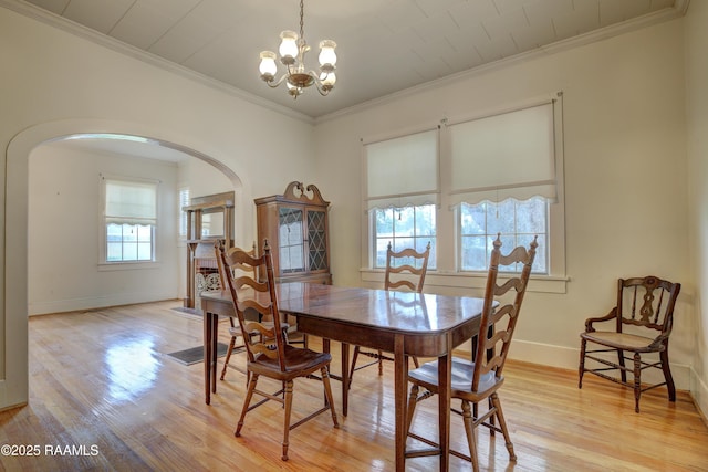 627 Weeks St, New Iberia, LA 70560 - dining space featuring arched walkways, light wood-style floors, a chandelier, baseboards, and ornamental molding