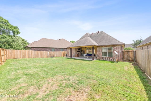 rear view of property featuring roof with shingles, a patio area, brick siding, a fenced backyard, and a yard
