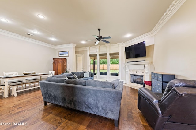 living room with a fireplace with flush hearth, ornamental molding, a ceiling fan, and dark wood-style flooring