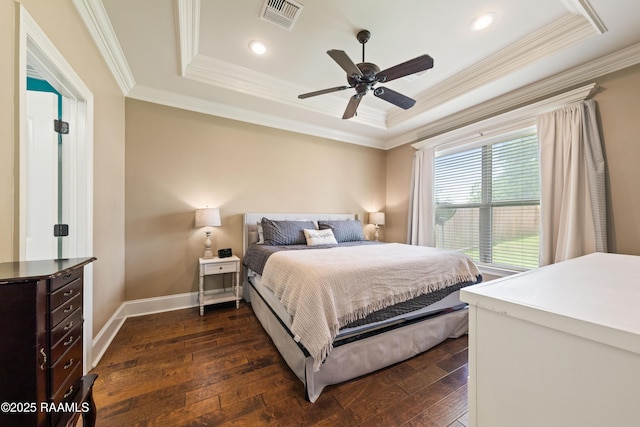 bedroom featuring visible vents, crown molding, dark wood finished floors, baseboards, and a tray ceiling