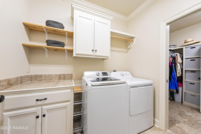 laundry area featuring cabinet space, independent washer and dryer, and crown molding