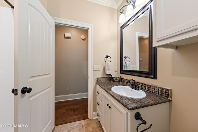 bathroom with vanity, ornamental molding, and baseboards