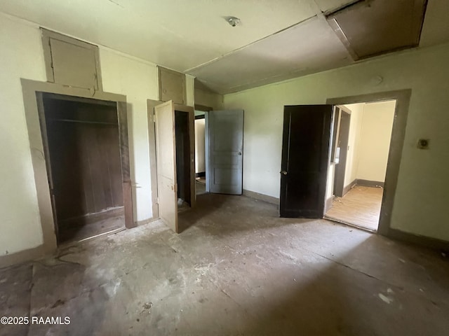unfurnished bedroom featuring baseboards and unfinished concrete flooring